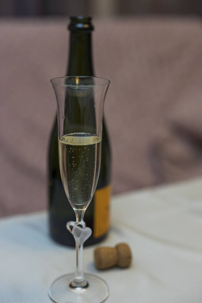 Großaufnahme von Champagnerglas auf offenem Flaschenhintergrund. Getränkekonzept.  - Foto, Bild