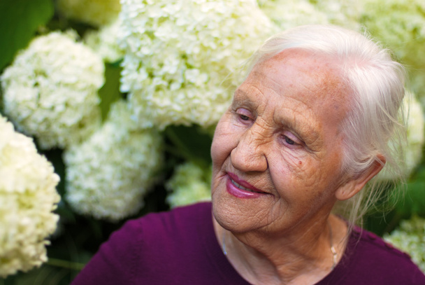 oudere vrouw in tuin - Foto, afbeelding