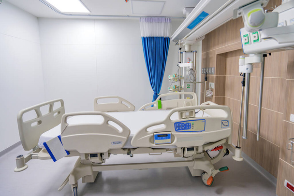 Hastane odasında tedavi ve rehabilitasyon için ayarlanabilir boş bir hasta yatağı.. - Fotoğraf, Görsel