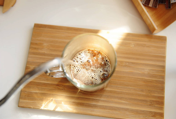 Brassage de café dans une tasse. Verser de l'eau de la bouilloire col de cygne dans une tasse vitreuse avec vue sur le café fraîchement moulu
 - Photo, image
