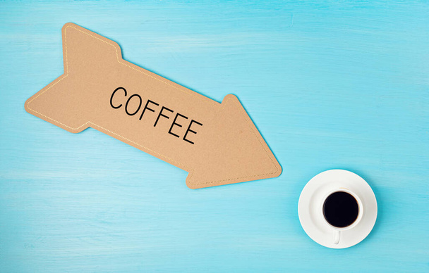 フラットコーヒーカップを指して矢印でレイアウトします。目覚め、朝のコーヒー、毎日の儀式、カフェのコンセプト - 写真・画像