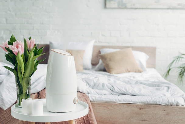 depuratore a ultrasuoni bianchi, tulipani e candele sul tavolo in camera da letto
  - Foto, immagini