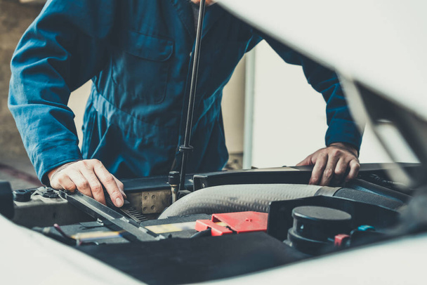 Professionele monteur die auto reparatie en onderhoud in de auto garage. Bedrijfsconcept autoservice. - Foto, afbeelding