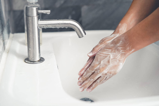 Hands washing for prevention of novel Coronavirus Disease 2019 or COVID-19 . People wash hands at bathroom sink to clean the virus infection. - Valokuva, kuva