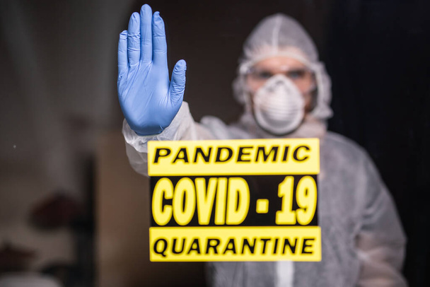 Man in protective suit and in protective medical mask showing stop gesture. Epidemiologist show stop palm. Stop coronavirus or covid-19 and the pandemic. Stay home. Quarantine concept. - Photo, Image