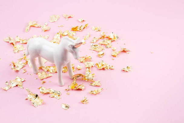 Unicornio blanco y brillo dorado sobre el fondo rosa. Estilo surrealista mágico de cuento de hadas. Composición mínima
 - Foto, imagen