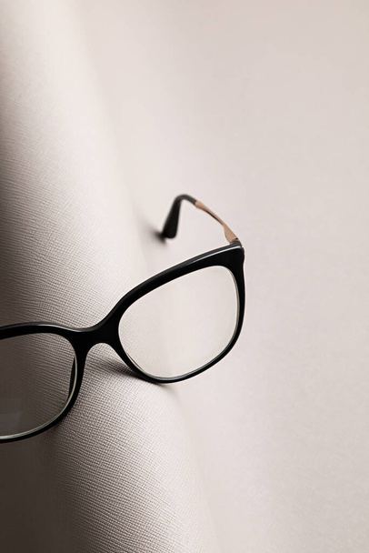 Óculos elegantes sobre fundo cinza. Loja óptica, seleção de óculos, teste ocular, exame de visão no óptico, conceito de acessórios de moda
 - Foto, Imagem