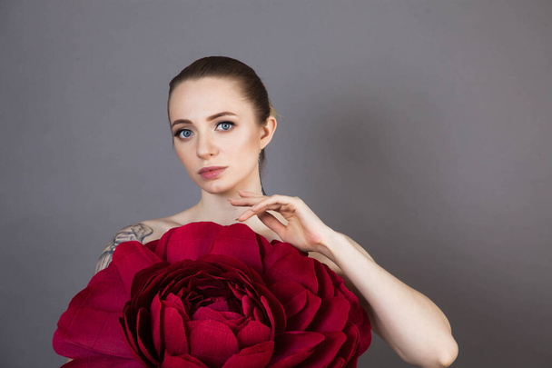beautiful girl with healthy skin relaxes after a Spa treatment with a red flower - Photo, Image
