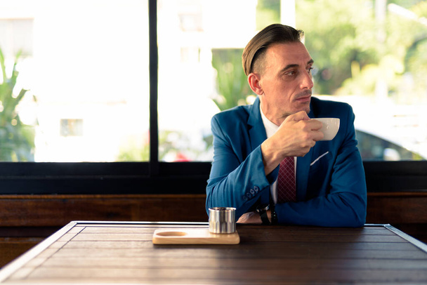 Portrait of mature handsome Italian businessman relaxing at the coffee shop - Fotografie, Obrázek
