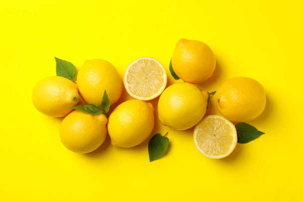 Lemons on yellow background, top view. Fresh fruit - Fotó, kép