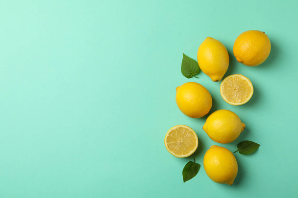Fresh lemons on mint background, top view. Ripe fruit - Foto, afbeelding
