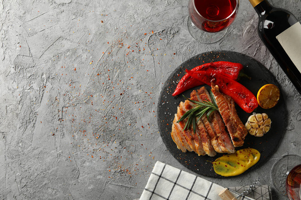 灰色の背景に揚げ豚肉ステーキ、野菜やワインをみじん切り。焼き料理 - 写真・画像