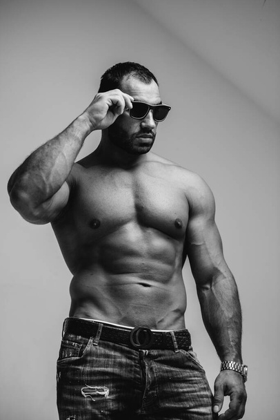 Seksowny sportowiec z nagim tułowiem nosi okulary. Odpoczynek, zdrowy styl życia - Zdjęcie, obraz