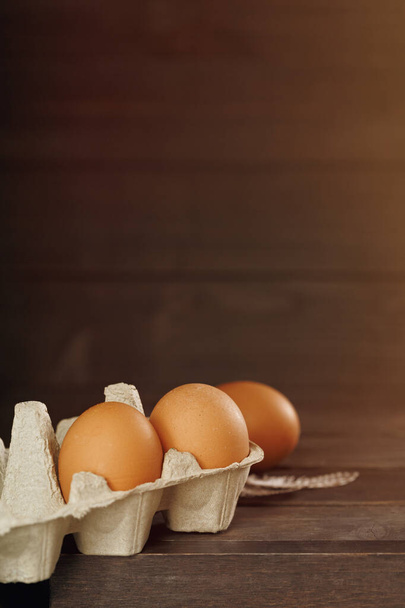 Huevos de gallina orgánicos frescos en bandeja sobre fondo de madera. Fondo de vacaciones rústico. Concepto de Pascua. Copiar espacio
 - Foto, Imagen