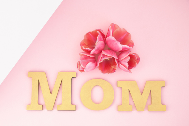 top view of tulips and mom lettering on pink and white background - Foto, immagini