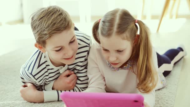 Teen brother and sister study with tablet at home due to coronavirus quarantine - Materiał filmowy, wideo