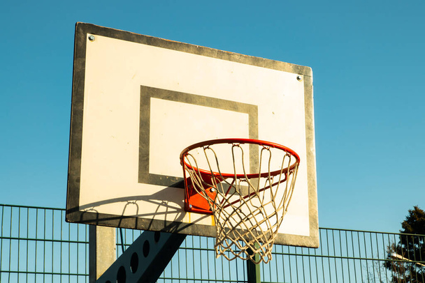 Καλάθι μπάσκετ στο δρόμο ενάντια στον γαλάζιο ουρανό - Φωτογραφία, εικόνα