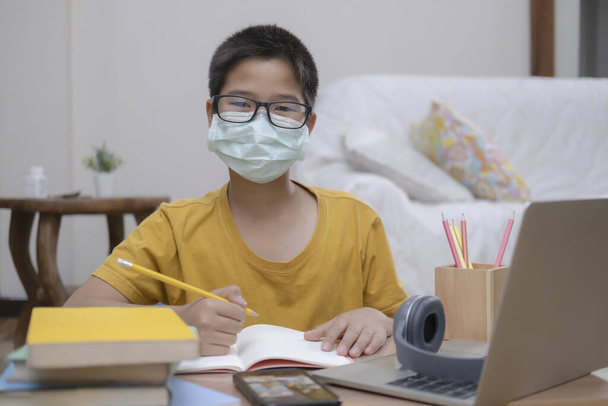 Boy wearing face masks online study homeshcooling at home. - Fotoğraf, Görsel