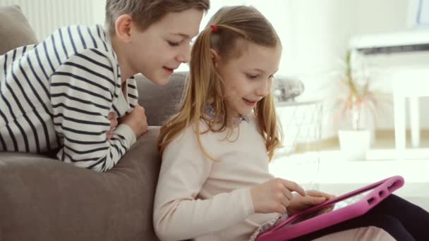 Teen brother and sister study with tablet at home due to coronavirus quarantine - Materiał filmowy, wideo