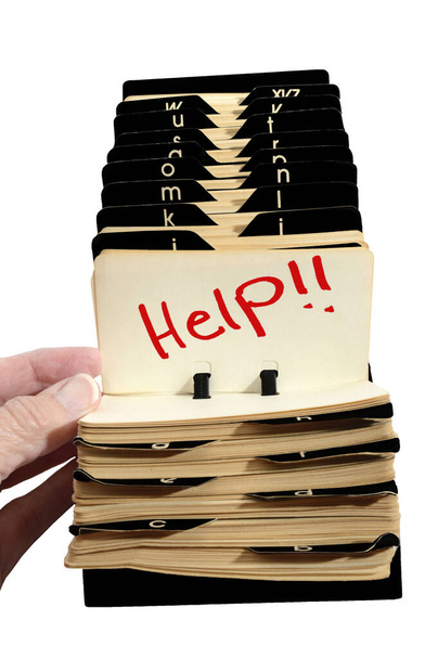Vertical shot of an old Rolodex with a lady's hand opening it to Help!! in red.  White background. - Photo, Image