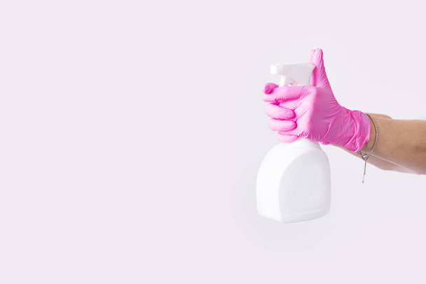 Hand in Hand in Latex rosa medizinische Schutzhandschuhe weißes antibakterielles Desinfektionsmittel. Coronavirus optimistisches Hygienekonzept. Kopierraum. - Foto, Bild