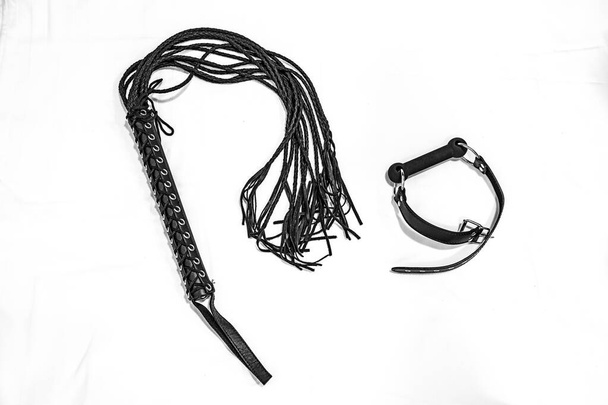 Zwarte geseling en paardengrap op witte achtergrond. BDSM-concept. - Foto, afbeelding