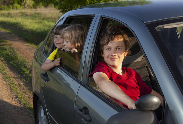 Χαμογελαστή οικογένεια με παιδιά στο αυτοκίνητο. Έννοια διακοπών και ταξιδιού - Φωτογραφία, εικόνα