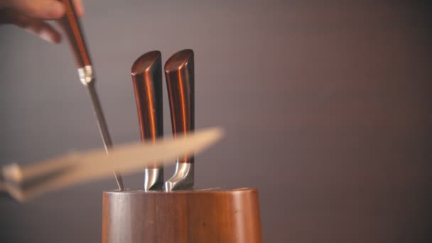 木製のナイフホルダーからナイフを取る人 - 映像、動画