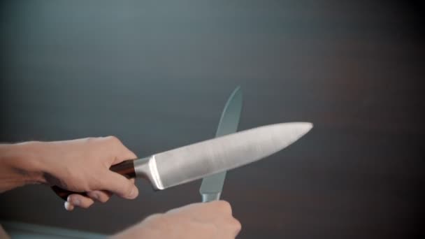 Ένα άτομο που ακονίζει μαχαίρια μεταξύ τους - Πλάνα, βίντεο