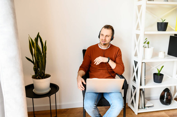 Guy uses headsets and laptops to work at home - Fotografie, Obrázek