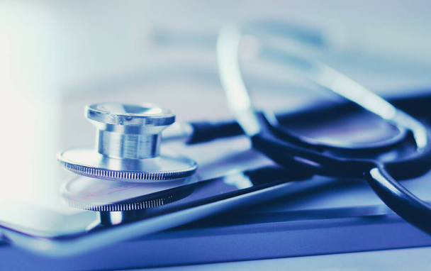 Matériel médical : stéthoscope bleu et comprimé sur fond blanc. Matériel médical - Photo, image