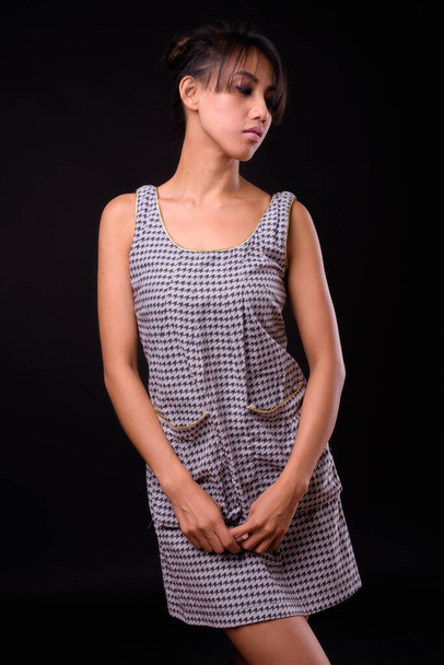 Studio shot of young beautiful Filipino woman against black background - Foto, immagini