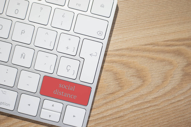 Keyboard with the red social distance button. Concept for any illustration of teleworking or telecommuting, self-employed, home workers by coronavirus. - Photo, Image