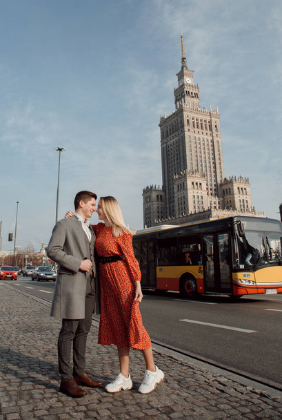 egy fiatal pár, akik európai városokat utaznak. Szerelmi történet Varsóban. A srác a lánnyal végigsétál a város utcáin. - Fotó, kép