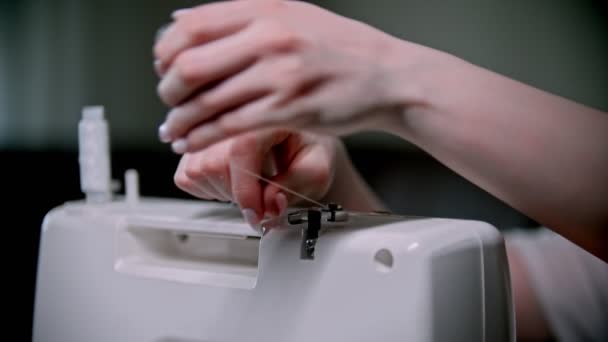Рука швеи накладывает на швейную машинку пачку ниток
 - Кадры, видео