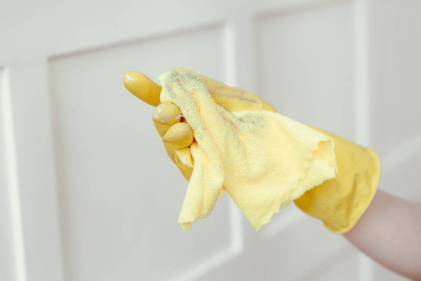 Dust and dirt on the yellow cloth. The concept of cleaning at the weekend. Female hand in glove wipe the dust. - Foto, Bild