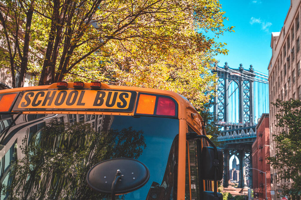 Brooklyn Bridge, New York, USA - 21 May, 2019: School bus in Brooklyn with a Manhattan bridge in the background. - Fotó, kép