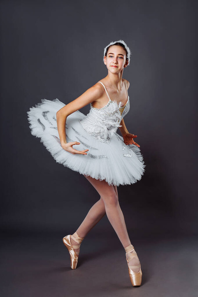 Retrato clássico de bailarina de ballet. Bela bailarina graciosa em tutu branco da prática do lago Swan liberar posição de balé no estúdio. Imagem vertical de jovem adolescente talentoso em pointe em hippies
 - Foto, Imagem