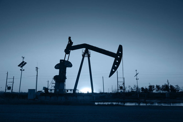 Scena pola naftowego, wieczór pompowania wiązki w sylwetce  - Zdjęcie, obraz