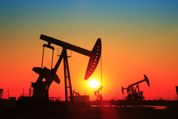Scena pola naftowego, wieczór pompowania wiązki w sylwetce  - Zdjęcie, obraz
