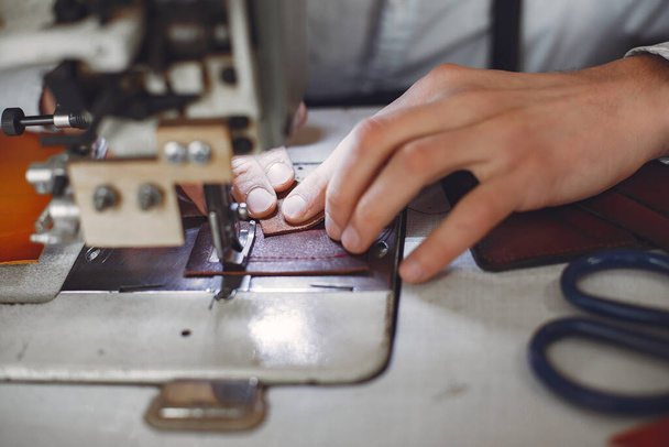 Man in a studio creates leather ware - Фото, изображение