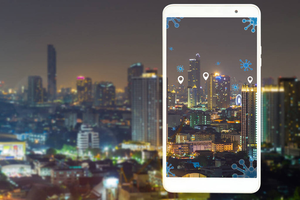 Nachtelijke stadsbeeld met een wit mobiel frame met viruspictogram meldpunt, colonavirus en technologie concept. - Foto, afbeelding