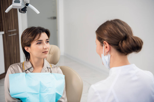 Closeup of a woman, patient, at the dentists listening to her doctor - Foto, immagini