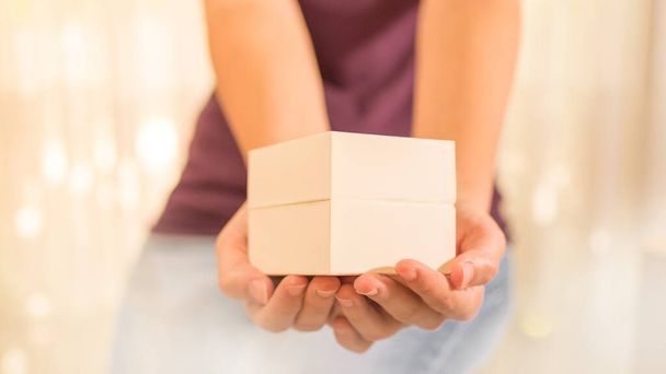 Foto stock das mãos de uma mulher dando uma pequena caixa
 - Foto, Imagem