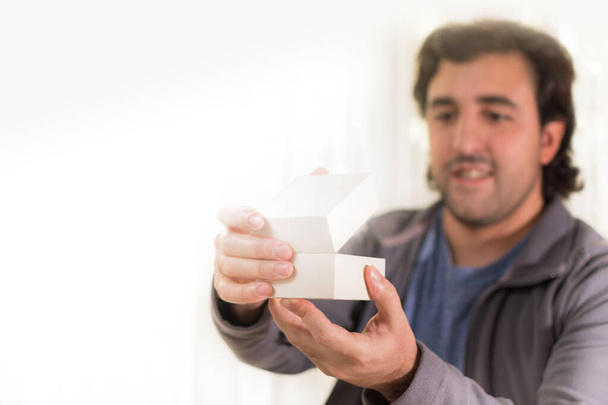 Man opening a small white box with happy expression - Foto, immagini