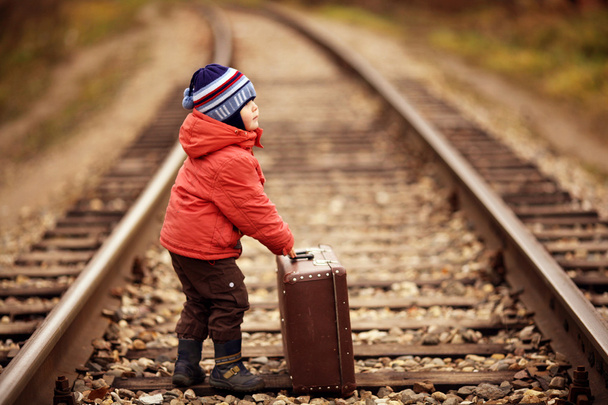 Little traveler with a suitcase on the railroad - Fotoğraf, Görsel