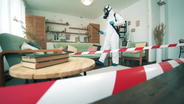 A nappalit fertőtleníti egy vegyvédelmi ruha specialista. - Felvétel, videó