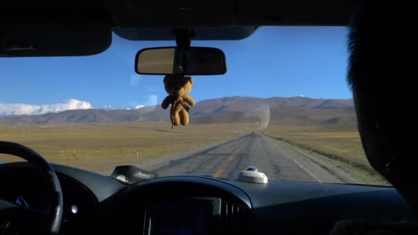 ПІДКАЗКА: Тедді - ведмідь висить на дзеркалі автомобіля, коли туристи досліджують Тибет.. - Кадри, відео