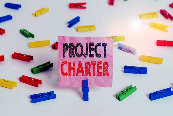 Conceptual hand writing showing Project Charter. Business photo text typically short formal document that describes your project Colored clothespin papers empty reminder white floor office. - Fotó, kép