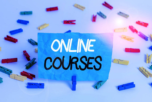 Handwriting text writing Online Courses. Concept meaning courses deliver a series of lessons to a web browser Colored clothespin papers empty reminder white floor background office. - Zdjęcie, obraz